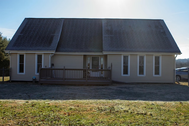 back of property with a wooden deck and a yard