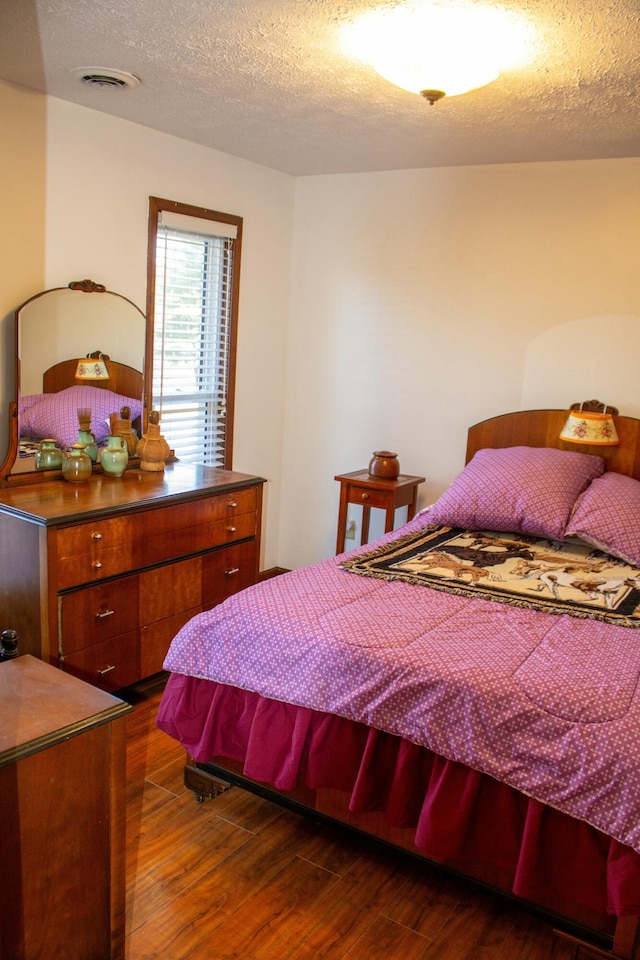 bedroom with dark wood-type flooring and a textured ceiling