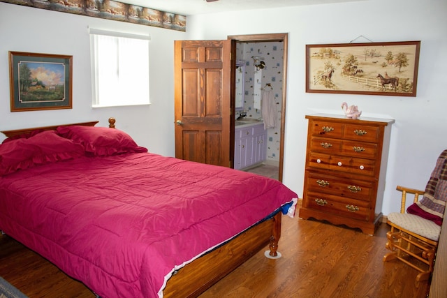 bedroom with hardwood / wood-style flooring and connected bathroom