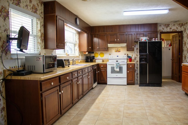 kitchen featuring sink, light tile patterned floors, a textured ceiling, and black appliances