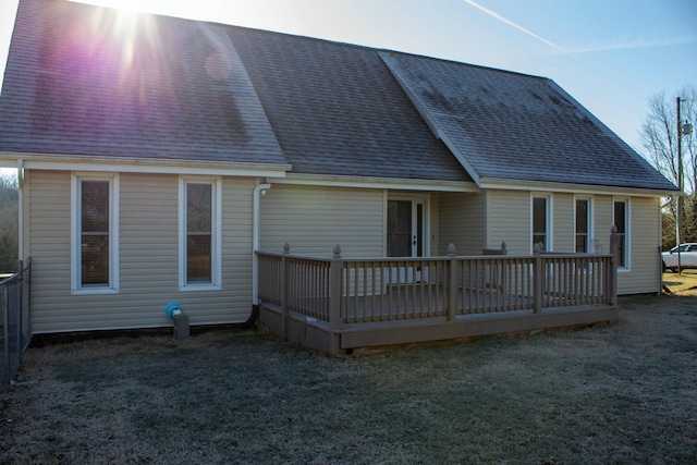 rear view of property featuring a yard and a deck