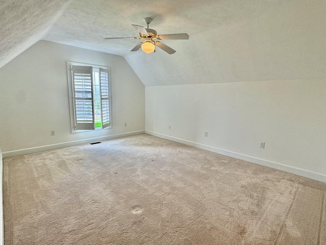 bonus room with a textured ceiling, ceiling fan, light carpet, and vaulted ceiling