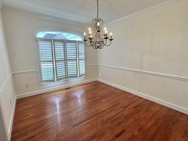 unfurnished dining area featuring ornamental molding, wood finished floors, a healthy amount of sunlight, and a notable chandelier