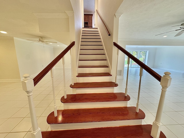 staircase featuring tile patterned flooring, a textured ceiling, ceiling fan, and crown molding