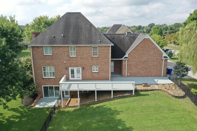 rear view of house featuring a lawn and a wooden deck