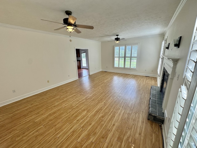 unfurnished living room featuring light wood-type flooring, ornamental molding, a textured ceiling, ceiling fan, and a fireplace