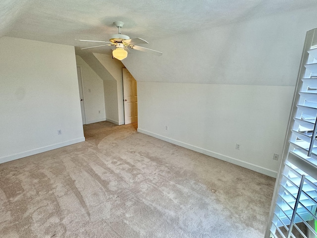 bonus room with light carpet, vaulted ceiling, and ceiling fan