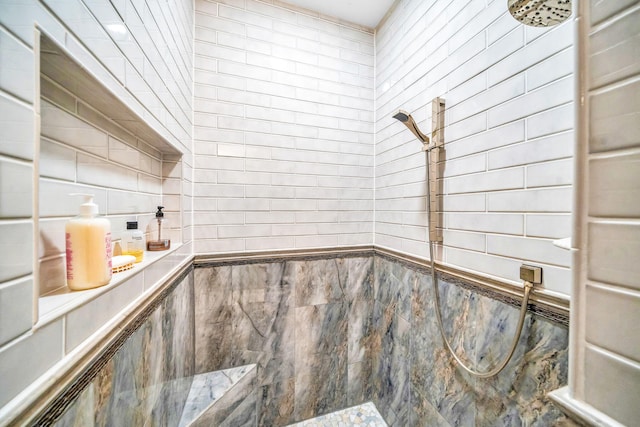 bathroom with a tile shower and tile walls