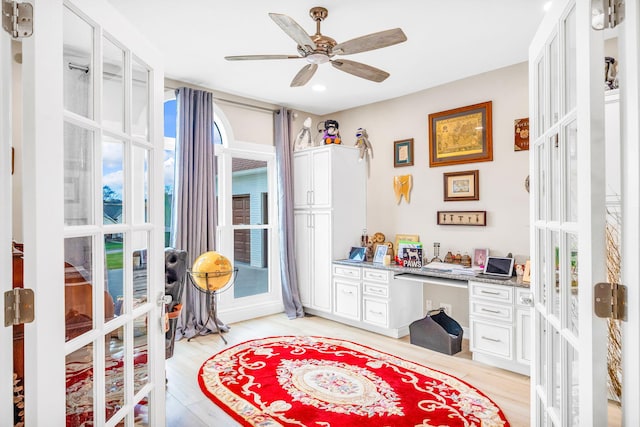 interior space with ceiling fan, light hardwood / wood-style flooring, built in desk, and french doors