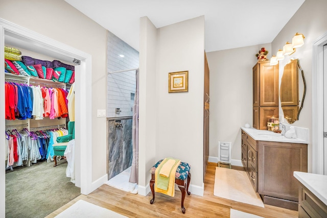 bathroom featuring hardwood / wood-style flooring, vanity, and a shower