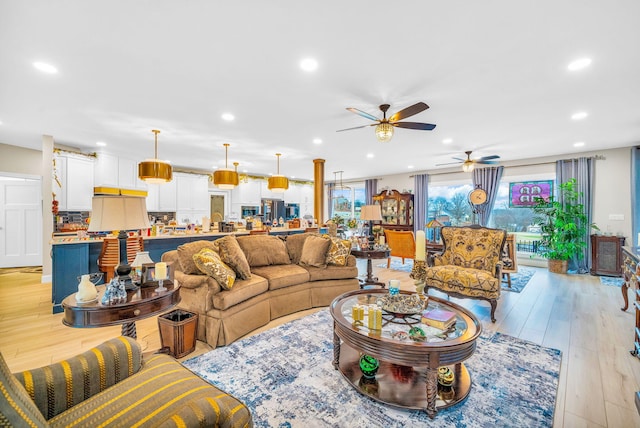 living room with ceiling fan and light hardwood / wood-style flooring