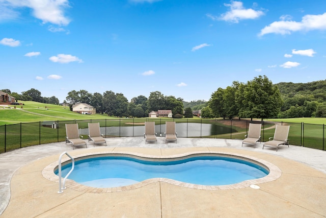 view of pool with a patio area and a yard