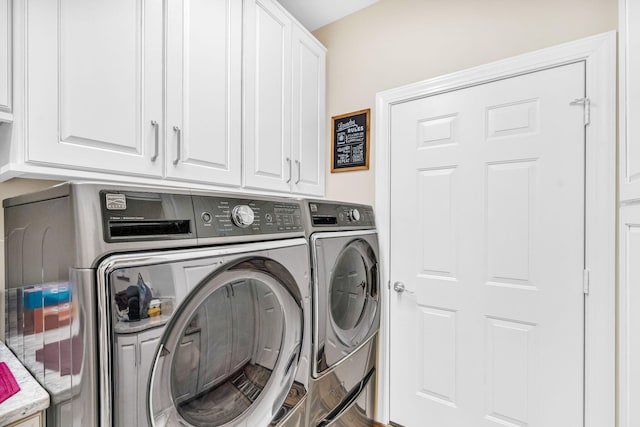 washroom with cabinets and washing machine and clothes dryer