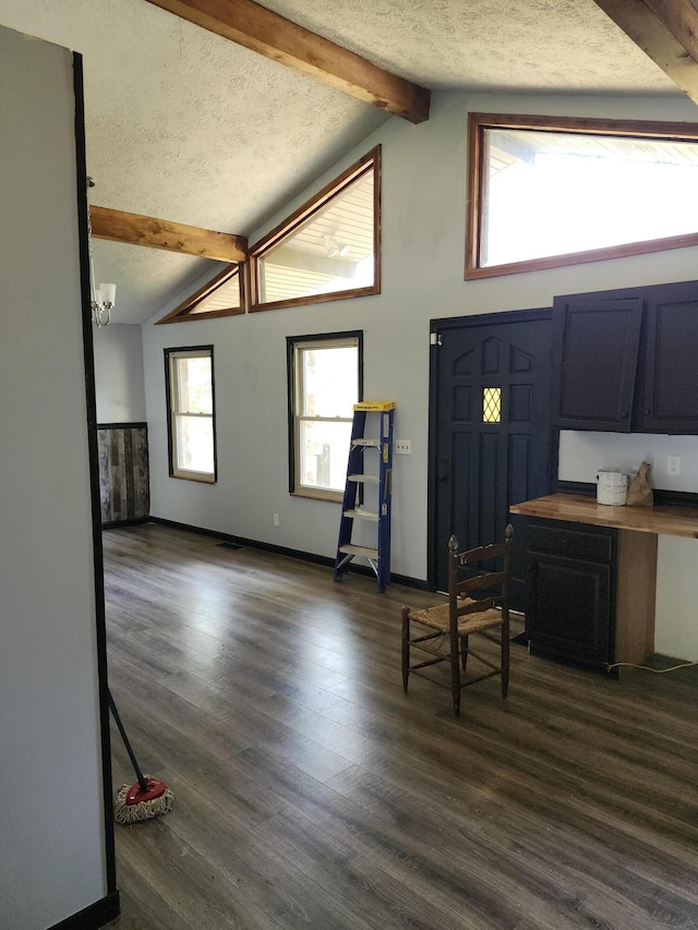 entryway featuring a chandelier, vaulted ceiling with beams, dark hardwood / wood-style flooring, and a textured ceiling