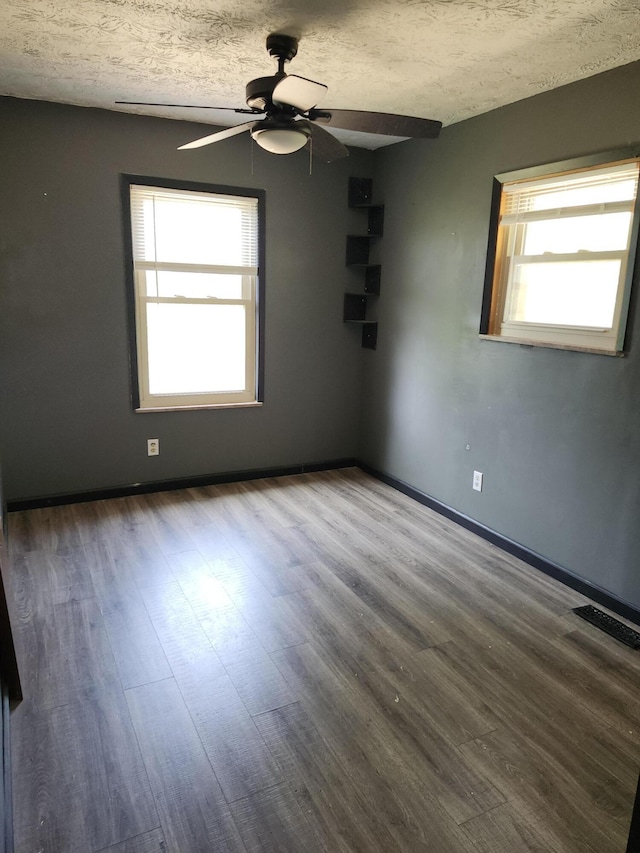 spare room with ceiling fan, a textured ceiling, and hardwood / wood-style flooring