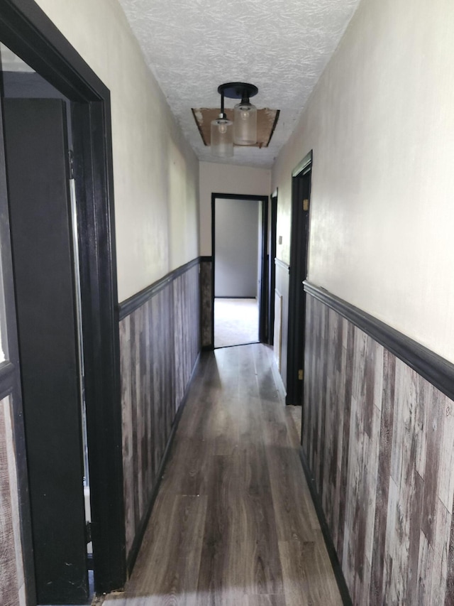 hallway featuring a textured ceiling and dark wood-type flooring