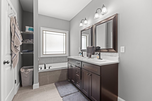 bathroom with tile patterned floors, tiled tub, and vanity