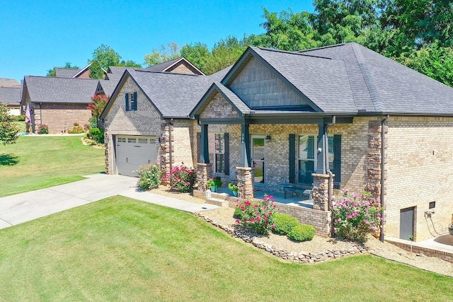 view of front of property featuring covered porch, a front yard, and a garage