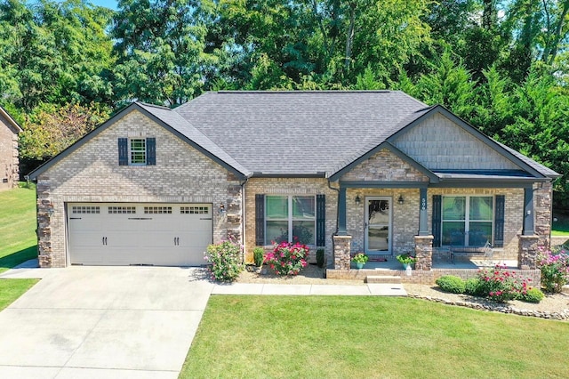 craftsman-style home featuring covered porch, a front lawn, and a garage