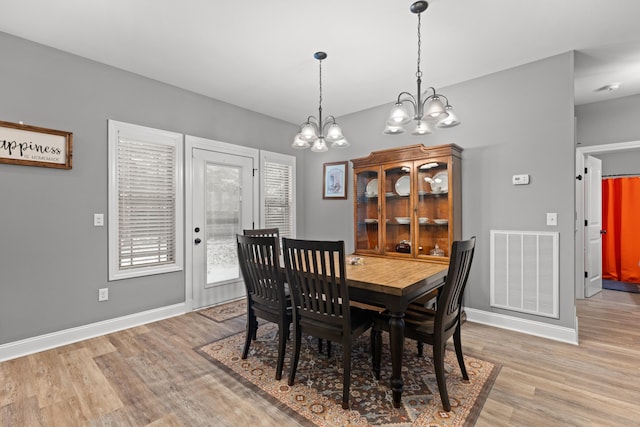 dining room featuring light hardwood / wood-style floors and a notable chandelier