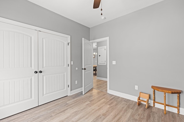 bedroom with ceiling fan, light wood-type flooring, and a closet