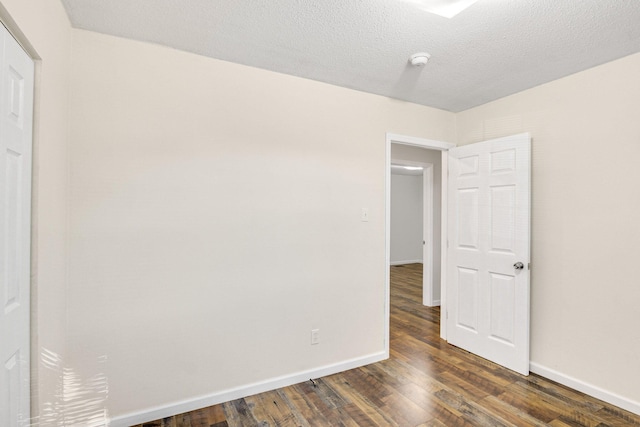 unfurnished room featuring a textured ceiling and dark wood-type flooring