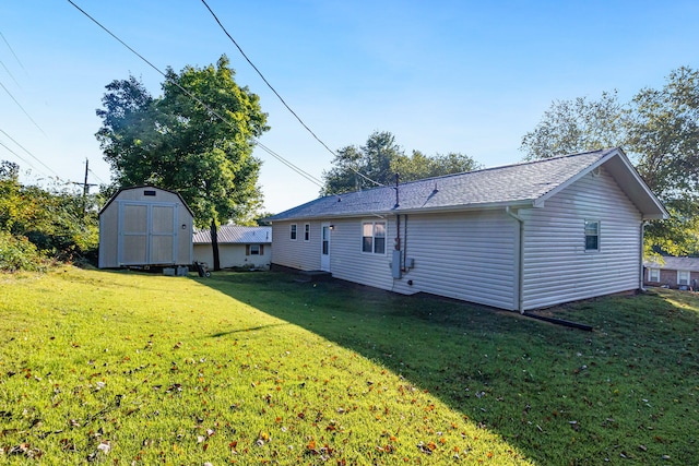 rear view of property with a storage unit and a lawn