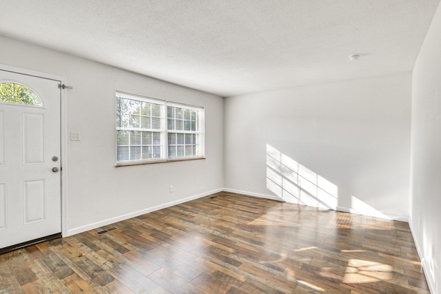 entrance foyer featuring dark hardwood / wood-style flooring and a textured ceiling