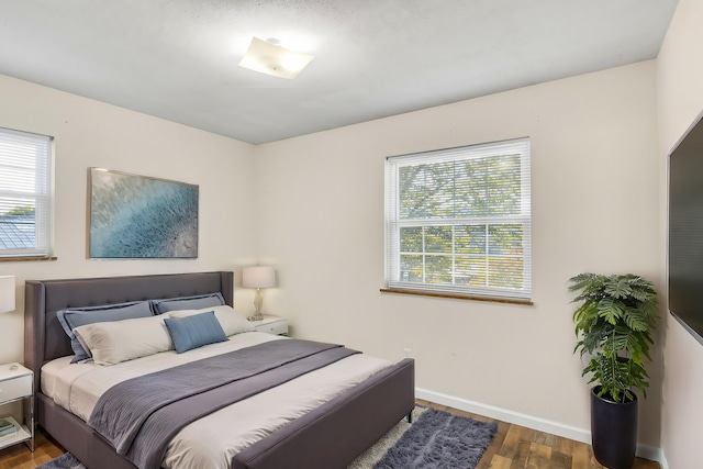 bedroom featuring dark hardwood / wood-style floors and multiple windows