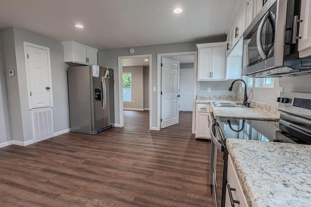 kitchen with dark wood-type flooring, sink, light stone counters, white cabinetry, and stainless steel appliances