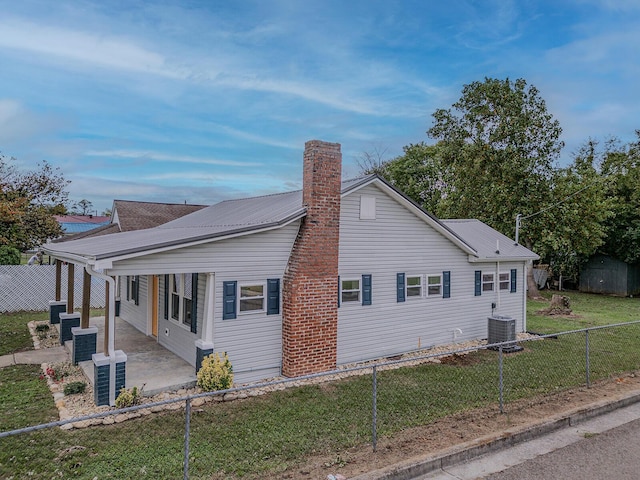 view of side of property with a patio and central air condition unit