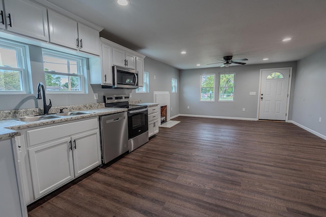 kitchen featuring white cabinets, ceiling fan, sink, and stainless steel appliances