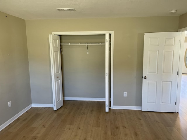 unfurnished bedroom featuring a closet and light wood-type flooring