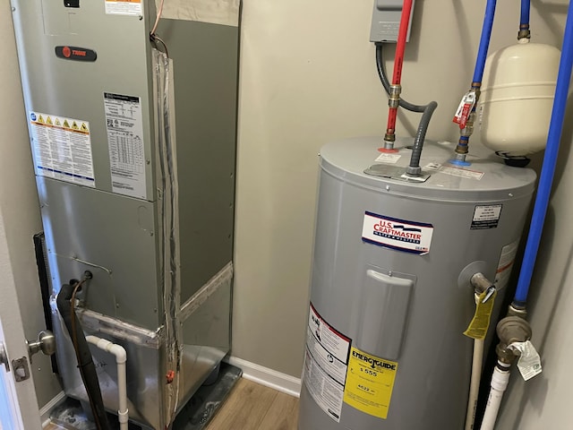 utility room featuring electric water heater and heating unit