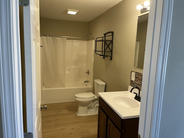 full bathroom with shower / tub combo with curtain, vanity, toilet, and wood-type flooring