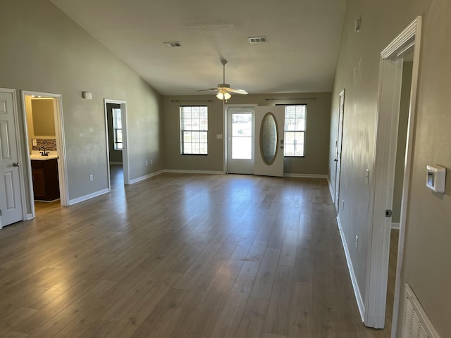 foyer entrance with ceiling fan, wood-type flooring, sink, and high vaulted ceiling