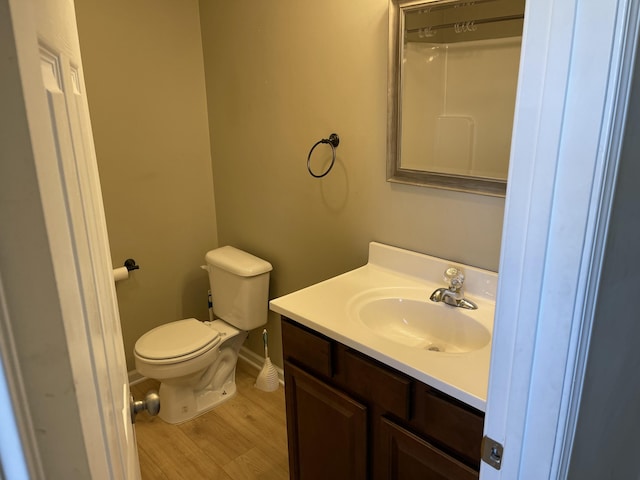 bathroom featuring vanity, hardwood / wood-style floors, walk in shower, and toilet