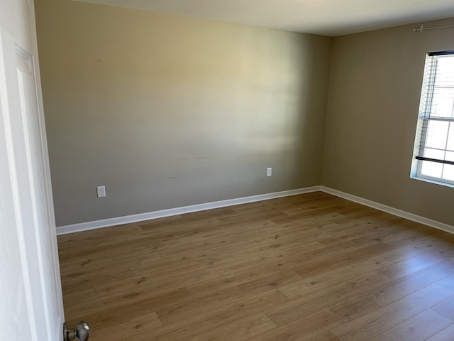 empty room with plenty of natural light and light hardwood / wood-style flooring