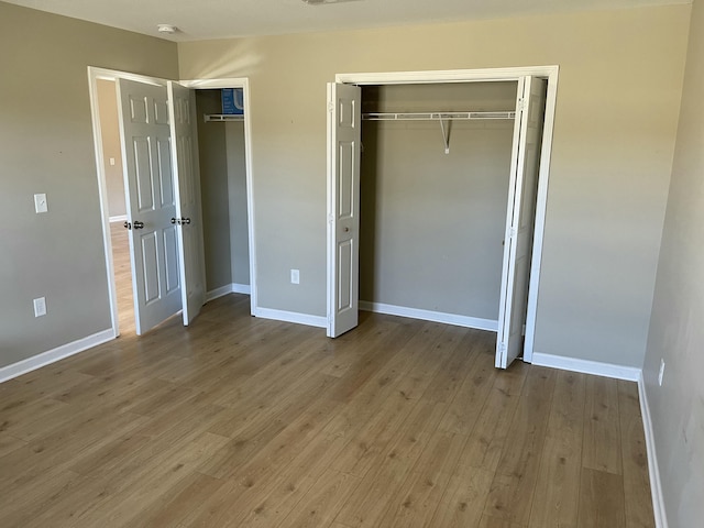 unfurnished bedroom featuring two closets and light hardwood / wood-style floors