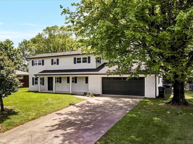 2121 Collins St, Morristown, TN 37814 - view of front of home featuring a garage, driveway, covered porch, a front yard, and brick siding