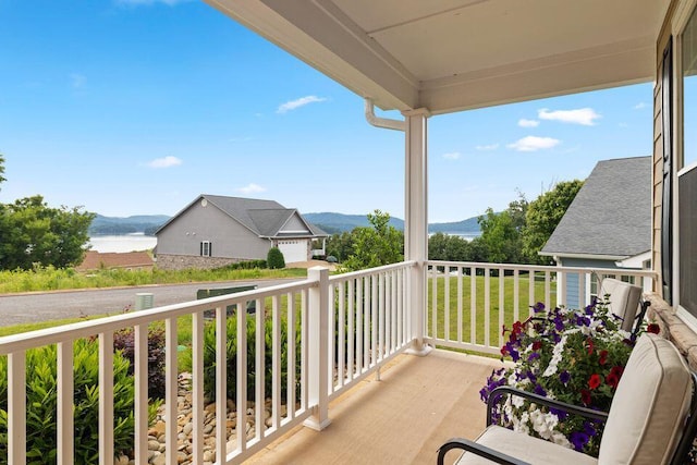 balcony featuring a water and mountain view