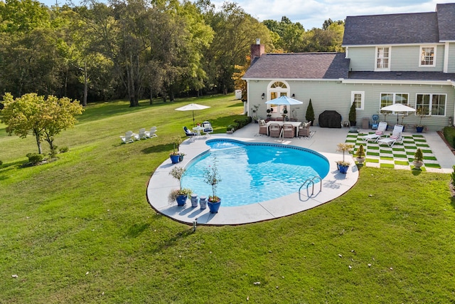 view of pool featuring a lawn and a patio area