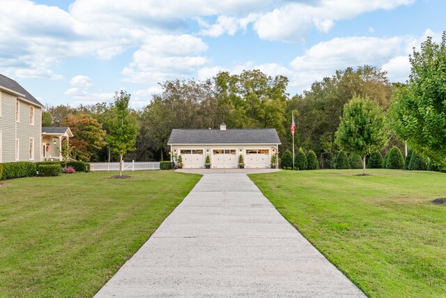 exterior space with a garage, an outdoor structure, and a front lawn