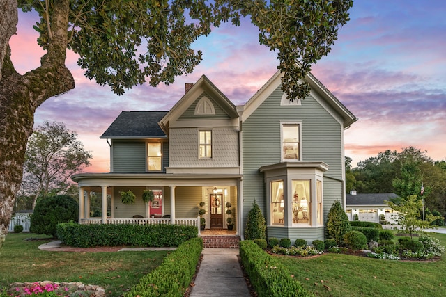 view of front of property featuring a lawn and a porch