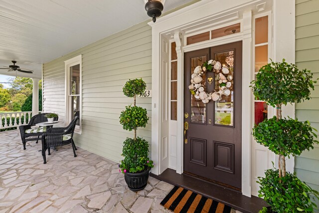 view of exterior entry with covered porch and ceiling fan