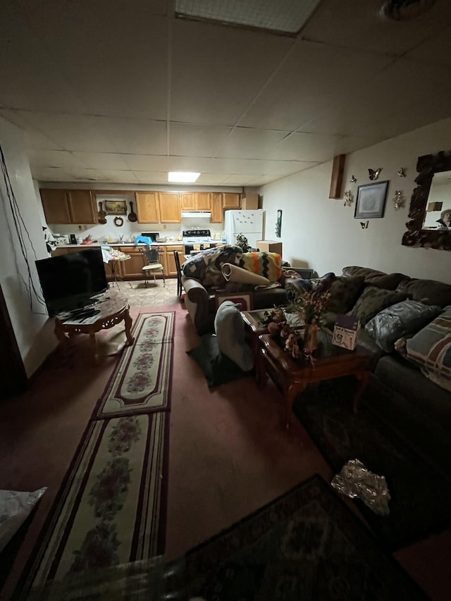 living room featuring a paneled ceiling and carpet