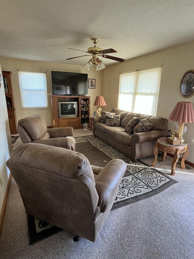 living room with carpet flooring, ceiling fan, and a textured ceiling