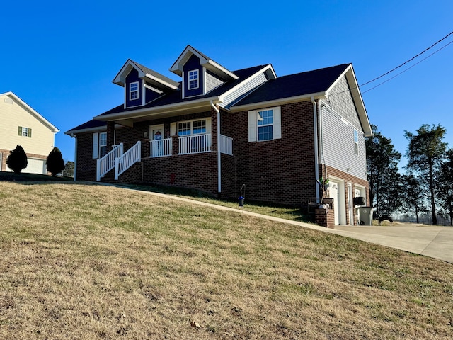 view of front of home featuring a front yard, covered porch, and a garage