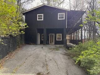 view of front facade featuring fence and aphalt driveway