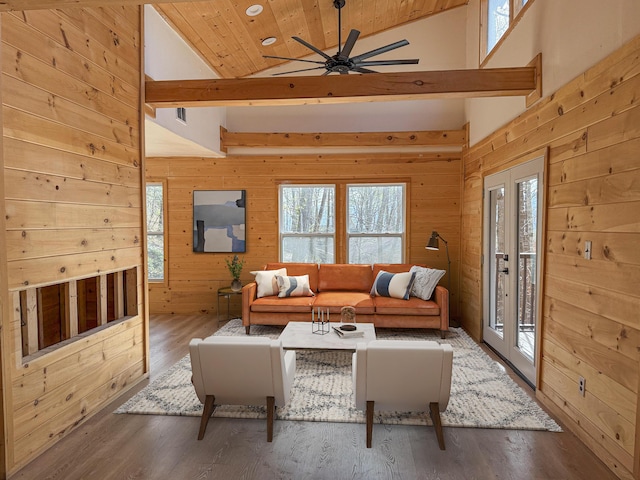living room featuring high vaulted ceiling, wood ceiling, wooden walls, ceiling fan, and wood finished floors